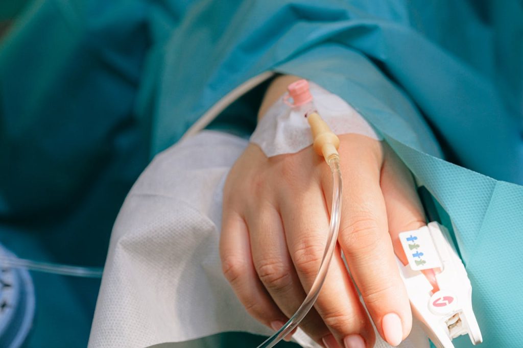 Close-up of a patients hand with intravenous therapy and pulse oximeter, symbolizing healthcare and treatment.